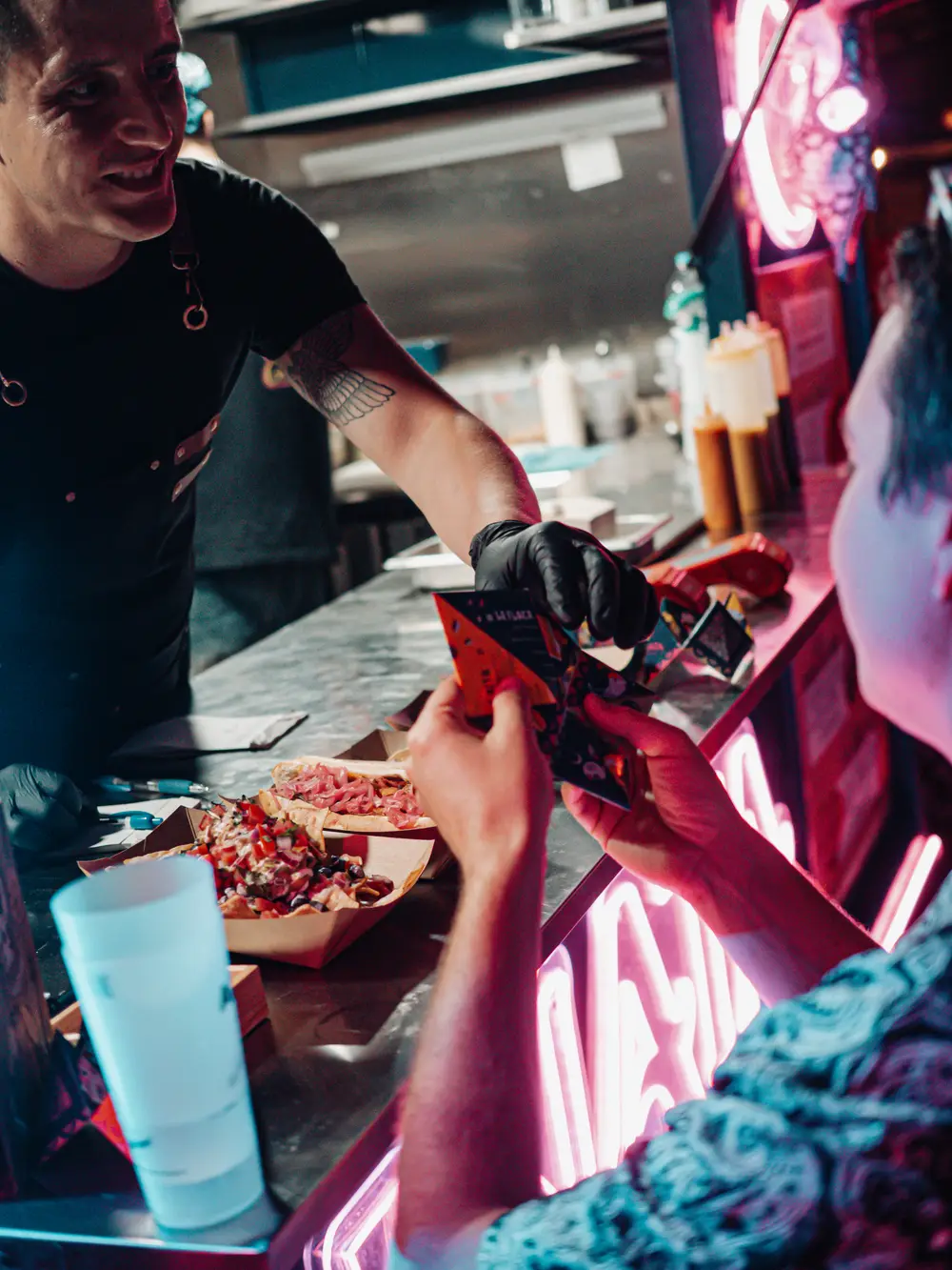 Un cocinero del Xolo Food Truck entrega tacos recién hechos a un invitado
